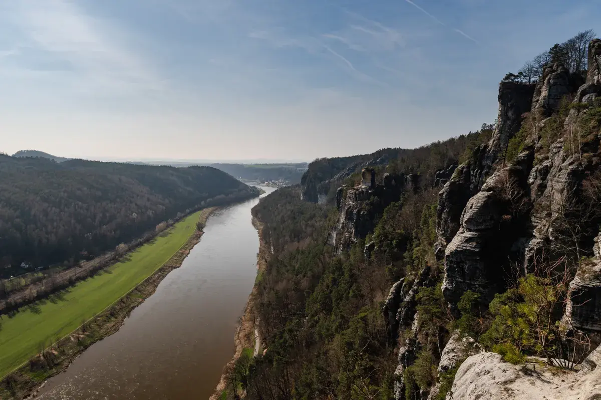 Blick von den Felsen auf die Elbe und die umliegenden Wälder. Eine perfekte Kulisse für eine **Rauenstein Wanderung**.