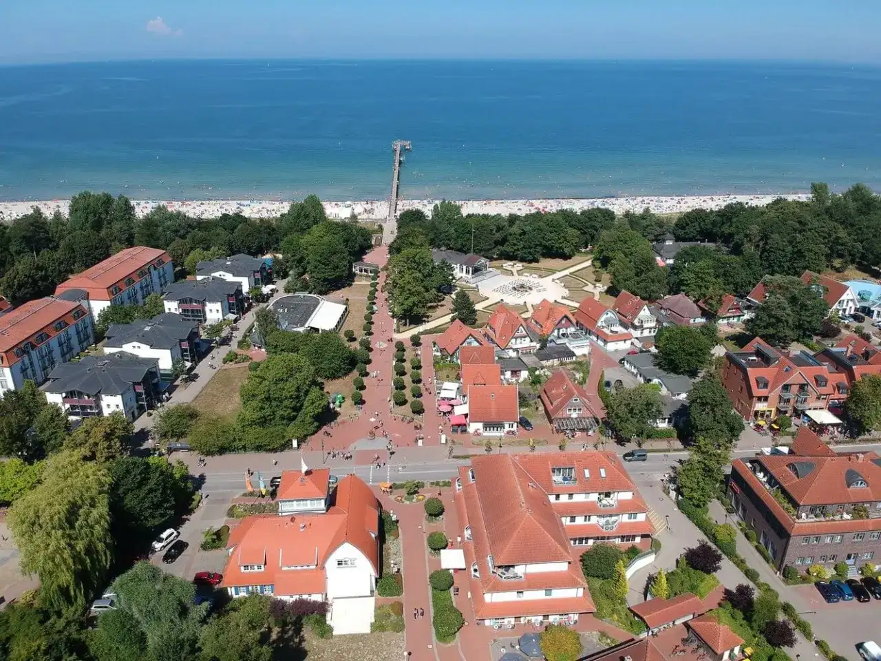 Luftaufnahme von Boltenhagen mit Strand, Promenade und roten Dächern. Hier finden sich viele Geheimtipps für einen entspannten Urlaub an der Ostsee.