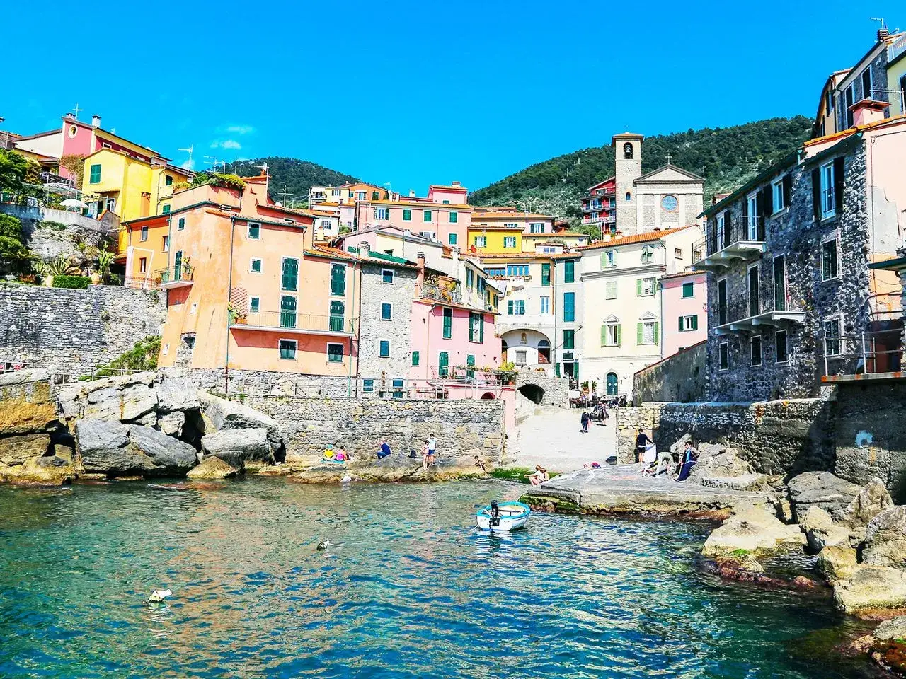 Bunte H&auml;user am Meer, ein versteckter Ort in Italien, der zu den Geheimtipps z&auml;hlt. T&uuml;rkises Wasser l&auml;dt zum Baden ein.