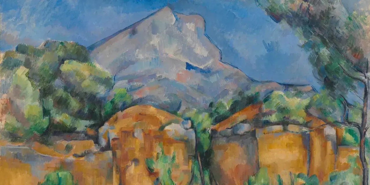 Berglandschaft bei Aix-en-Provence. Ein Berg ragt über grüne Bäume und ockerfarbene Felsen auf.