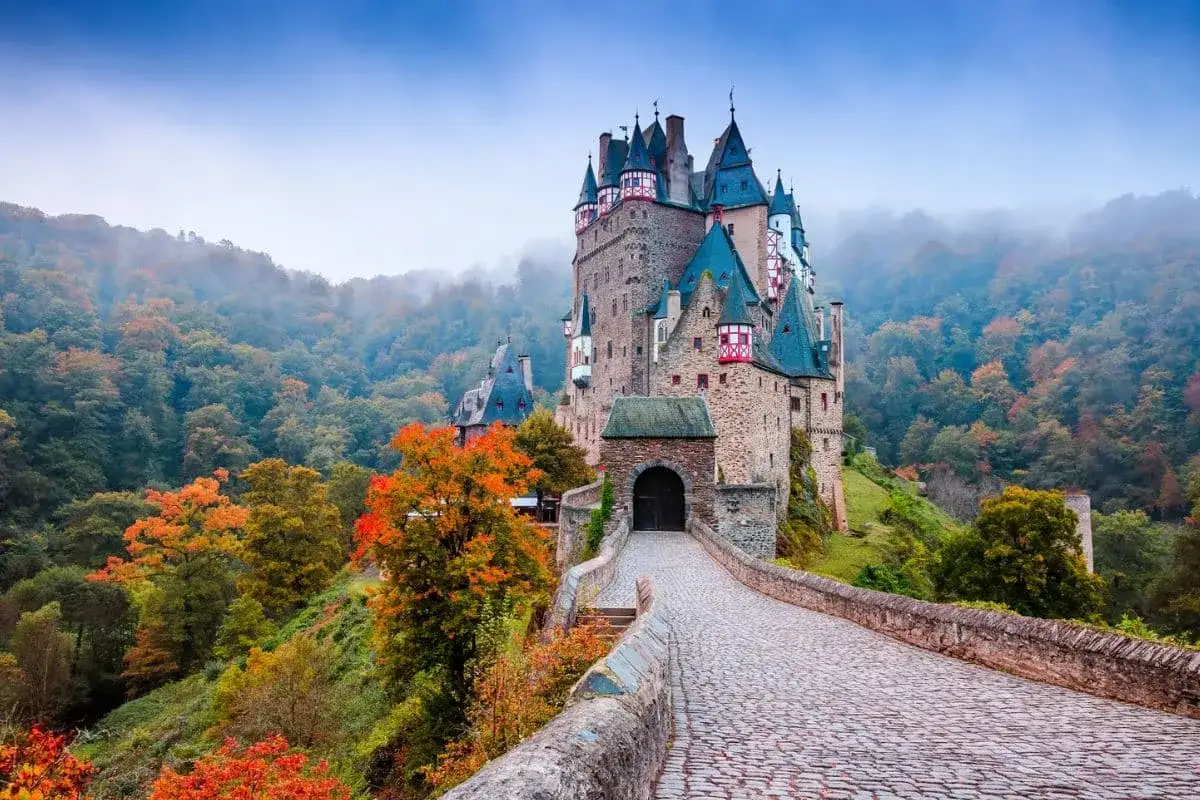 Burg Eltz, ein märchenhafter Ort, ist ein Geheimtipp in der Eifel. Umgeben von bunten Herbstwäldern, thront die mittelalterliche Burg auf einem Felsen.