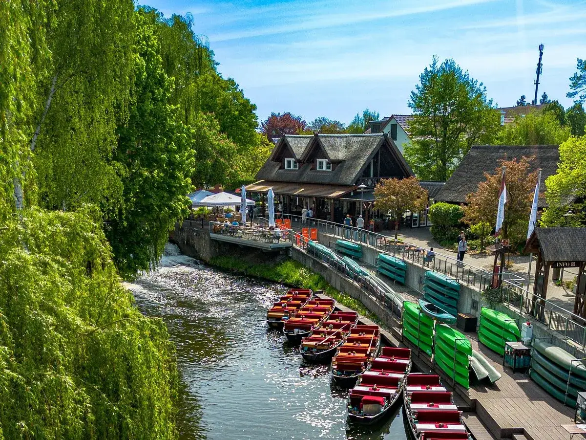 Boote liegen am Ufer in Burg Spreewald, bereit f&uuml;r eine Kahnfahrt durch die gr&uuml;ne Landschaft.