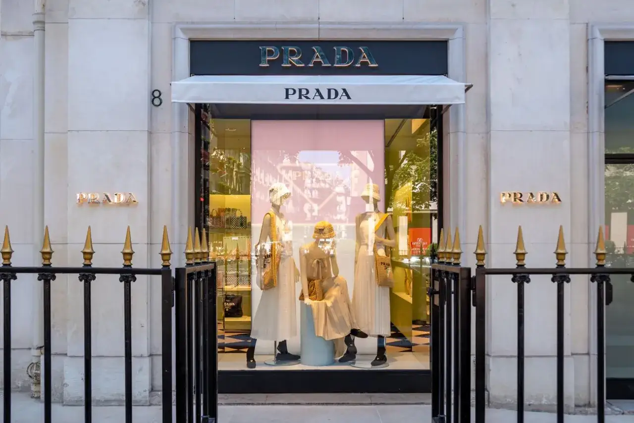 Prada-Schaufenster an der Avenue Montaigne mit eleganten Kleidern und H&uuml;ten auf Schaufensterpuppen.