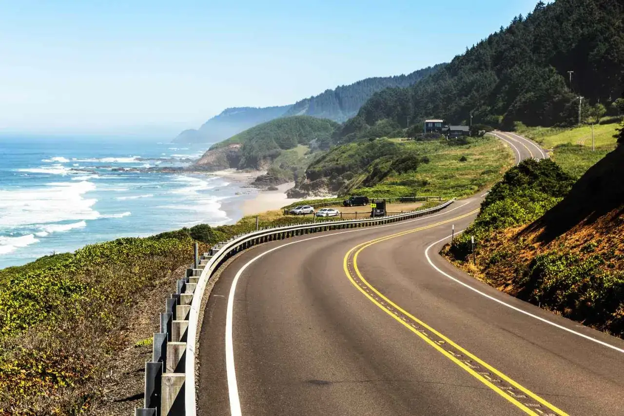 Kurvige K&uuml;stenstra&szlig;e in Oregon, mit Blick auf den Pazifik und bewaldete H&uuml;gel. Perfekt f&uuml;r einen unvergesslichen Oregon Road Trip.