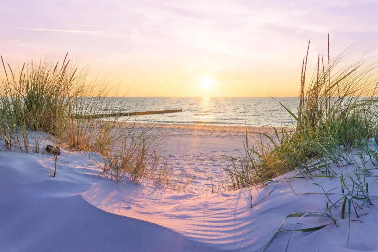 Sonnenuntergang am Ostseestrand mit D&uuml;nen und Strandhafer. Ein friedlicher Ort f&uuml;r entspannte Momente.