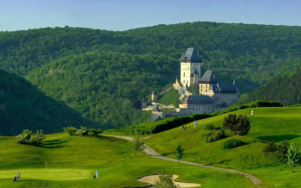 Ein Schloss thront &uuml;ber einem gr&uuml;nen Golfplatz. Perfekte Ausflugstipps f&uuml;r Prag und Umgebung.