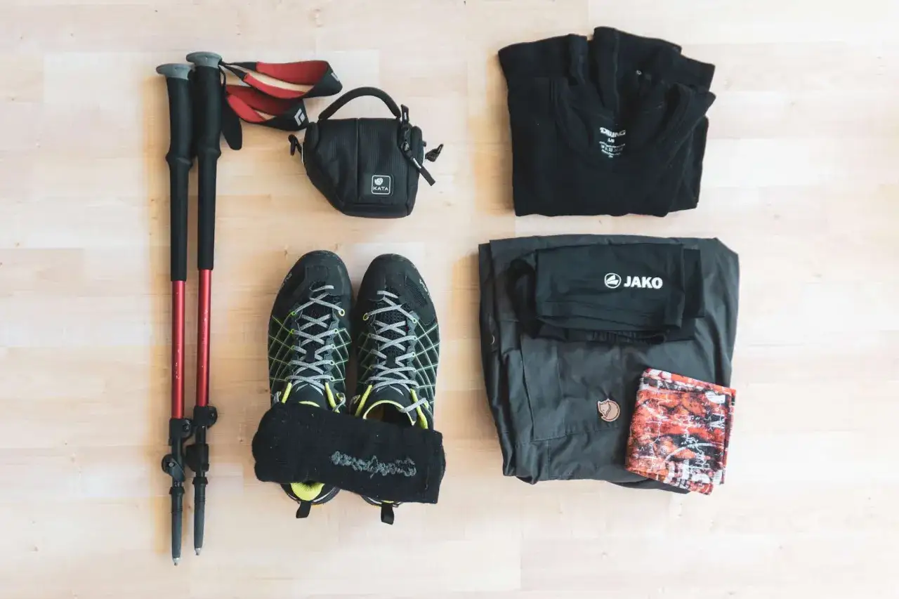 Wandern lernen: Trekkingst&ouml;cke, Wanderschuhe, Funktionskleidung und eine kleine Tasche liegen bereit f&uuml;r das n&auml;chste Abenteuer.