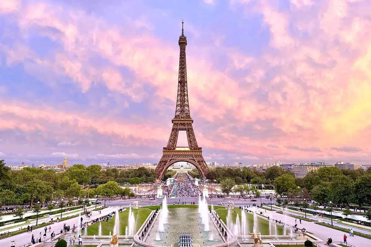 Eiffelturm im Abendrot, mit Brunnen und Menschen. Tolle Tipps f&uuml;r Paris!