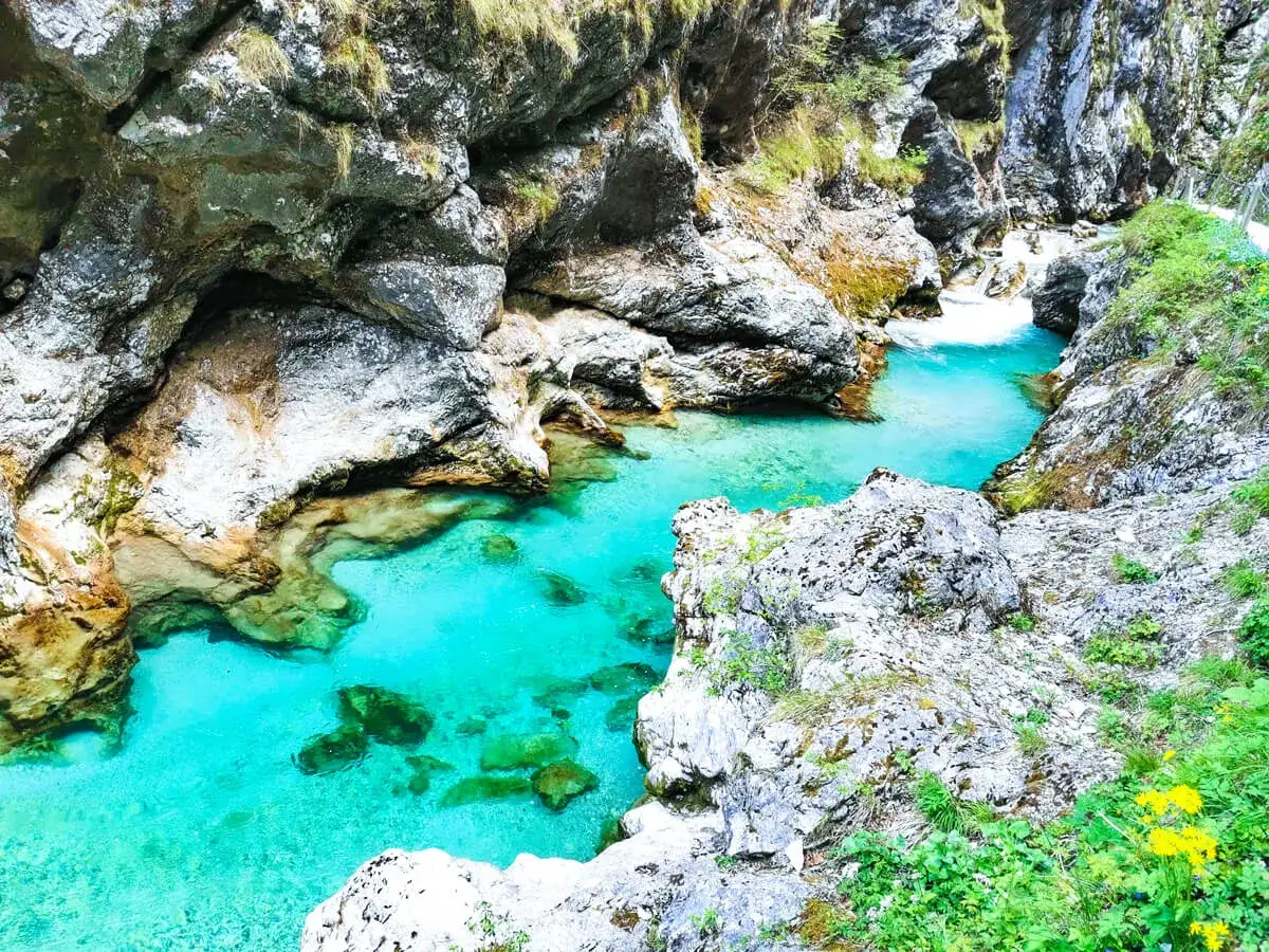 T&uuml;rkisfarbene Fl&uuml;sse schl&auml;ngeln sich durch die Schluchten von Soča, Slowenien. Felsige Ufer und &uuml;ppige Vegetation umgeben das kristallklare Wasser.