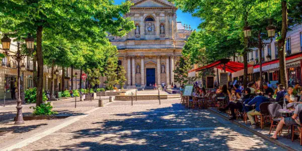 Ein sonniger Tag in Paris, mit Menschen, die in Cafés sitzen. Perfekt für alle unter 26, die Paris kostenlos erleben wollen.