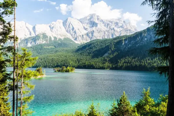 Türkisblaue See mit Inseln, umgeben von dichten Wäldern und majestätischen Bergen. Ein wahres Naturwunder Deutschlands.