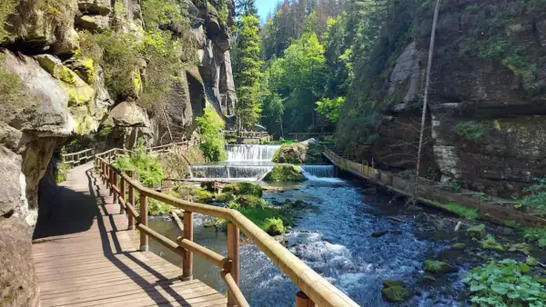 Holzstege schlängeln sich durch eine Schlucht mit Kaskaden. Ein perfekter Ort zum Hrensko wandern.