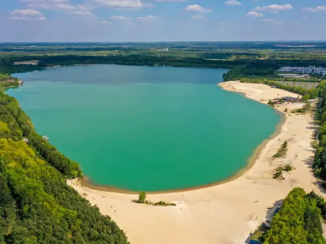 Türkisblaues Wasser lädt zum Baden ein. Ein idyllischer Badesee NRW mit Sandstrand und grünen Ufern.